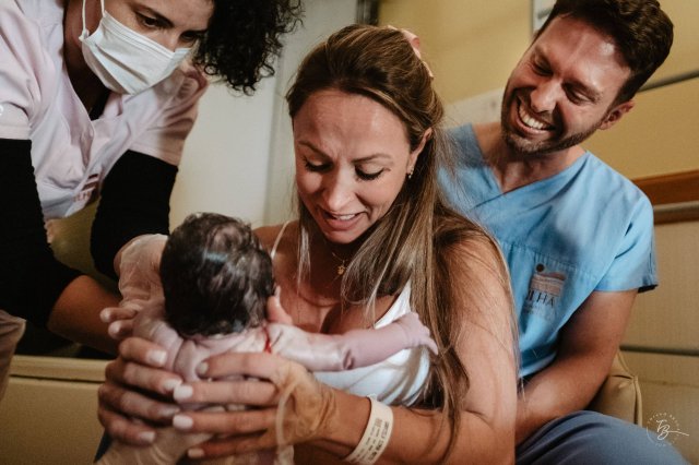 Радостный момент: новые родители держат своего новорожденного в родильной палате